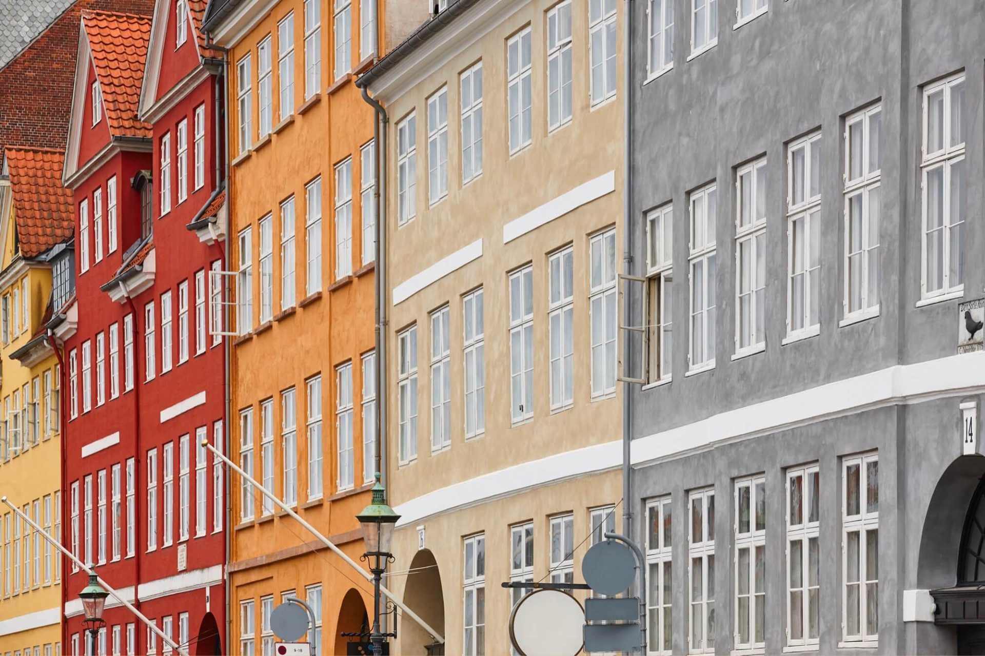 Klassiskt designade stadshus i en palett av rött, gult och grått står i rad